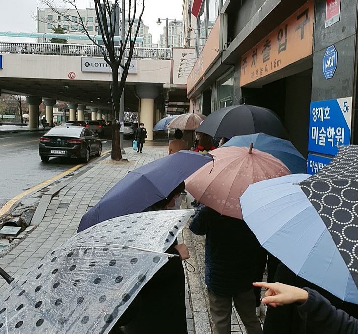 10일 우산을 쓴 시민들이 공적 마스크 구매를 위해 줄을 서고 있다. 사진=박규리 기자