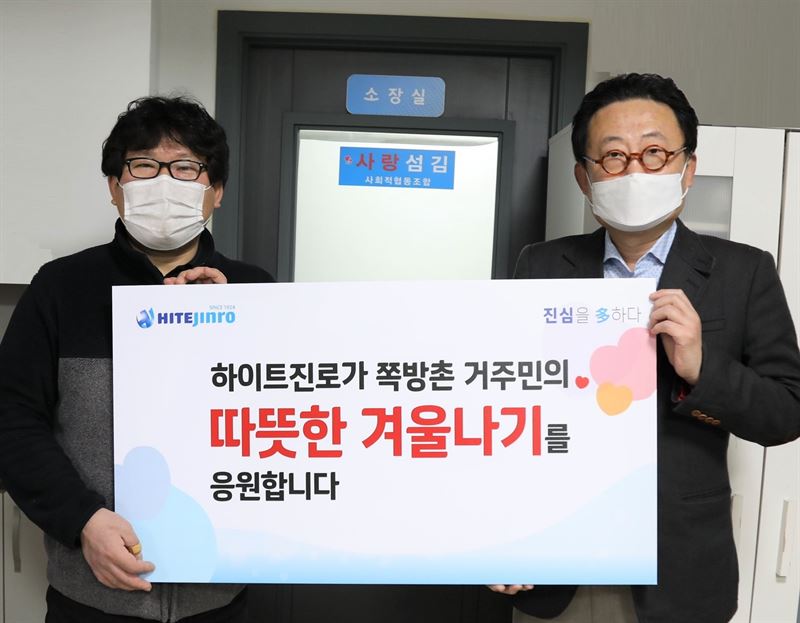 25일 하이트진로 류준형 상무(오른쪽)은 영등포 쪽방상담소 김형옥 소장을 만나 쪽방촌 거주민을 위한 떡과 핫팩을 전달했다.하이트진로 제공