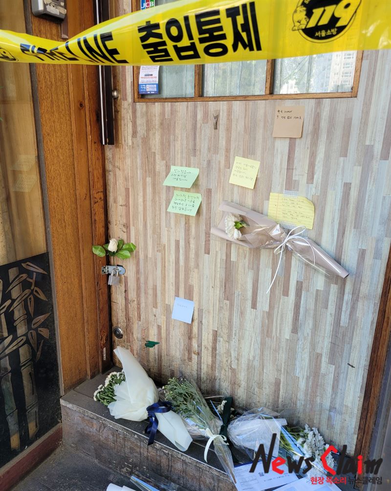 출입통제선이 설치된 서울 마포구에 위치한 맥주집 입구에 14일 국화꽃다발과 추모 메시지가 놓여 있다. 사진=김동길 기자