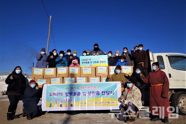 몽골 카스 희망의 숲 인근 하늘마을 주민들이 푸른아시아의 현지 활동가와 따숨박스 전달식에 참석해 기념사진을 찍고 있다. 사진=오비맥주