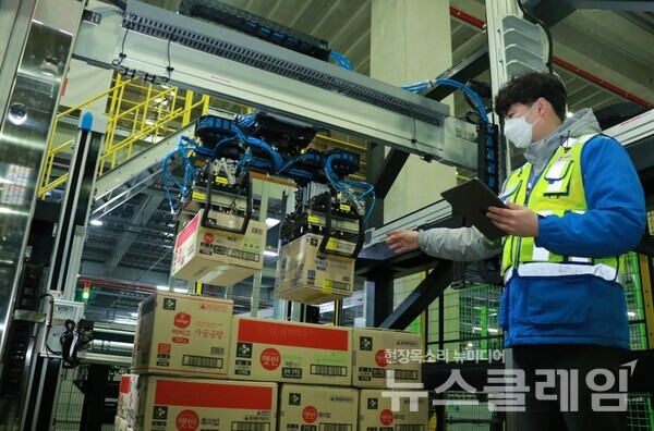 CJ대한통운 동탄 풀필먼트센터에서 ‘AI 로봇 디팔레타이저’가 박스를 컨베이어벨트로 옮기고 있다. 사진=CJ대한통운