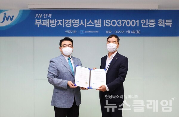 백승호 JW신약 대표이사(오른쪽)가 지난 4일 서울 서초동 본사에서 이원기 한국컴플라이언스인증원장에게 ISO37001 인증서를 받은 뒤 기념촬영을 하고 있다. 사진=JW홀딩스