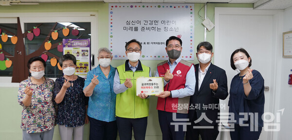 롯데건설 주택사업본부 이부용 본부장(오른쪽에서 세 번째), 유성훈 금천구청장(오른쪽 네 번째)과 관계자들이 함께 기증판을 전달하고 있다. 사진=롯데건설