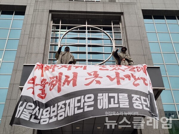 서울보증재단 콜센터 노동자 2명이 18일 새벽 서울 마포구 소재 서울신용보증재단 본사 정문 캐노피에 올라 고공농성에 돌입했다. 사진=서울신용보증재단고객센터지부