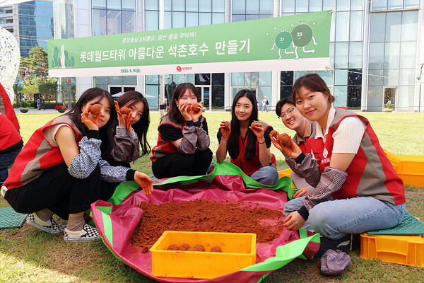 롯데물산 임직원들이 아름다운 석촌호수를 만들기 위한 ‘EM흙공 던지기’ 활동에 동참하고 있다. 롯데물산 제공