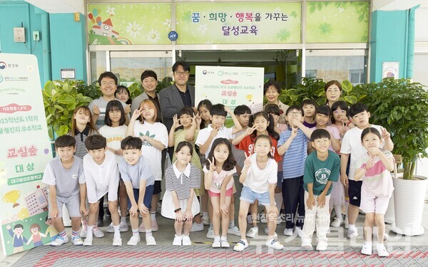 지난 10일 더현대 대구 임직원들이 정부 탄소중립 프로그램 ‘기후행동 1.5℃ 스쿨챌린지’에서 대상을 받은 대구광역시 달성초등학교를 방문해 공기정화식물을 전달하고 학생 및 선생님들과 기념사진을 찍고 있다. 사진=현대백화점