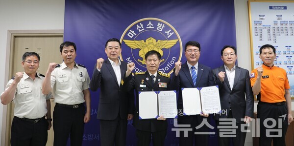 김인규 하이트진로 대표(왼쪽 세번째), 박재우 하이트진로 마산공장장(오른쪽 세번째), 이선장 마산소방서장(가운데)이 참석해 업무협약을 체결했다. 사진=하이트진로