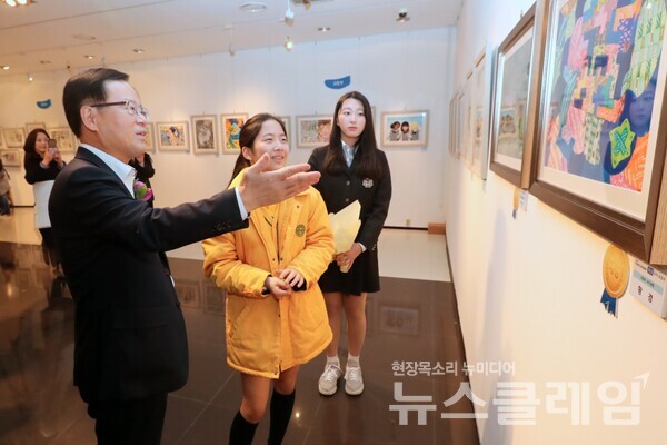 조병규 은행장이 ‘제26회 우리은행 우리미술대회’ 수상자로부터 수상 작품에 대해 설명을 듣고 있다. 우리은행 제공