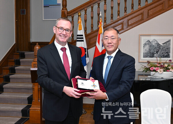 정의선 현대차그룹 회장이 대영제국 지휘관 훈장을 들고 콜린 크룩스(Colin Crooks) 주한 영국 대사와 기념촬영 하고 있다. 현대차그룹 제공