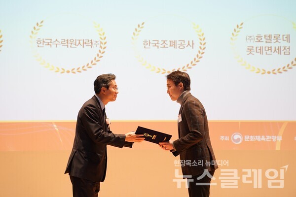 지난 15일 이세훈 롯데면세점 HR팀장(오른쪽)이 유병채 문화체육관광부 문화예술정책실장(왼쪽)으로부터 여가친화기업 인증패를 받고 있다. 롯데면세점 제공