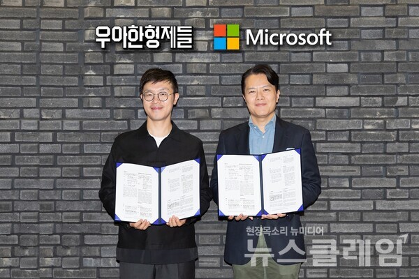우아한형제들 이기호 최고제품책임자(왼쪽)와 한국마이크로소프트 고광범 엔터프라이즈 커머셜 사업부문장이 업무협약 체결 후 기념사진을 촬영하고 있다. 우아한형제들 제공