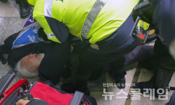 박경석 전장연 상임공동대표가 24일 서울 종로구 혜화역에서 열린 서울교통공사 전장연 시민 불복종 지하철 행동 원천봉쇄에 대한 입장발표 기자회견에서 경찰에 연행당하던 도중 바닥에 쓰러져 있다. 사진=전장연