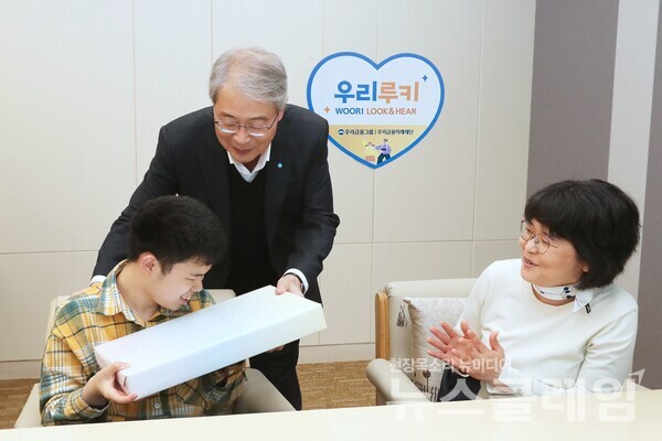 임종룡 우리금융그룹 임종룡 회장(가운데)이 초청 가족에게 선물을 전달하고 있다. 우리금융그룹 제공