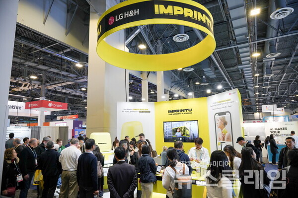 9일(현지시간) 미국 라스베이거스 CES 2024 행사장에 차려진 LG생활건강 미니 타투 프린터 '임프린투(IMPRINTU)' 부스에 많은 관람객들이 모여 타투 시연을 체험 또는 관람하고 있다. LG생활건강 제공