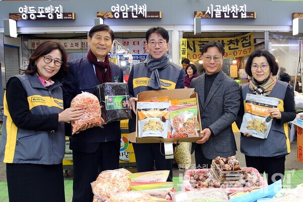 30일 서울시 영등포구 소재 영등포 전통시장에서 진행된 '2024 설날맞이 전통시장 사랑나눔 행사'에서 김태원 영등포시장 상인회장(우측에서 두 번째)과 전응림 희망친구 기아대책 부회장(좌측에서 두 번째), 이재근 KB국민은행장(가운데)이 기념사진을 촬영하고 있다. KB국민은행 제공