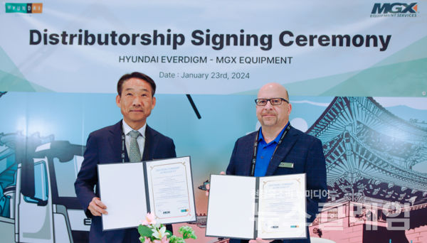 지난 1월 미국 라스베이거스 컨벤션 센터에서 임명진 현대에버다임 대표(사진 왼쪽)가 Mark Hoffmann(마크 호프먼) MGX Equipment Services 부사장과 딜러십 계약 체결 후 기념사진을 촬영하고 있다. 현대백화점그룹 제공