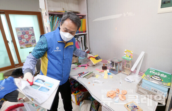 봉사활동에 참석한 진옥동 신한금융그룹 회장이 다자녀 가정에 방문해 환경 정리를 하고 있다. 신한금융그룹 제공