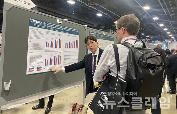 문석용 대웅제약 임상연구팀원(왼쪽)이 해외 의료진에 펙수클루의 주증상 완화율 관련 포스터를 소개하고 있다. 대웅제약 제공