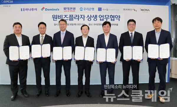 우리은행이 서울 중구 소재 우리은행 본점에서 원비즈플라자 상생 업무협약식을 진행했다. (왼쪽부터)하나투어 이대훈 상무, 도미노피자 김영훈 사장, 롯데관광 백현 대표이사, 우리은행 조병규 은행장, 나이스디앤비 오유근 대표이사, 모나용평 김진수 부사장, 특허법인다나 진희동 대표 변리사가 협약식 이후 기념사진을 촬영하고 있다. 우리은행 제공