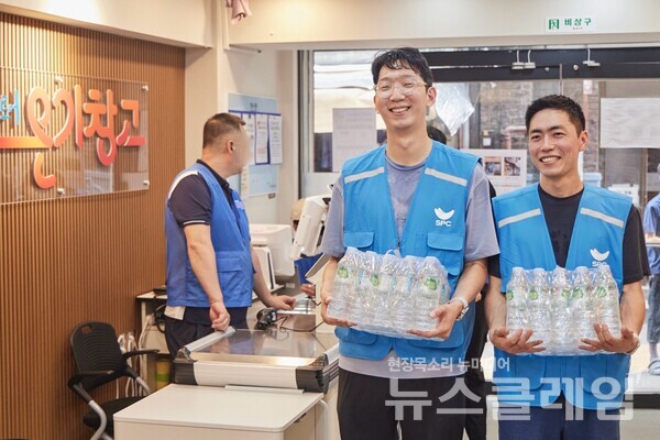 지난 12일 서울 용산구 서울역쪽방상담소가 운영하는 나눔스토어 ‘온기창고’에서 SPC그룹 임직원들이 생수를 전달하고 물품 정리 봉사활동을 진행하고 있다. SPC그룹 제공