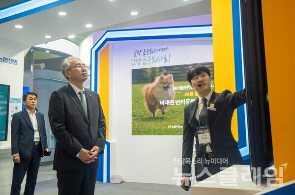 이석준 NH농협금융지주 회장(가운데)이 NHAX 체험관에서 NH투자증권의 ‘차트분석AI’ 서비스를 보고 있다. NH농협금융 제공