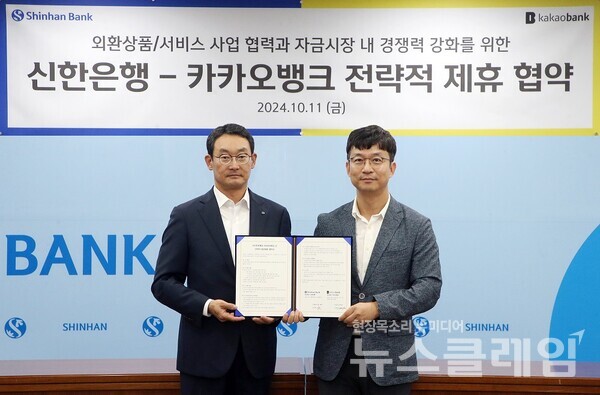 지난 11일 서울시 중구 신한은행 본점에서 진행된 ‘신한은행-카카오뱅크 전략적 제휴 협약식’에서 신한은행 김광수 고객솔루션 그룹장(왼쪽)과 카카오뱅크 이형주 최고비즈니스책임자(오른쪽)가 기념촬영을 하고 있다. 신한은행 제공