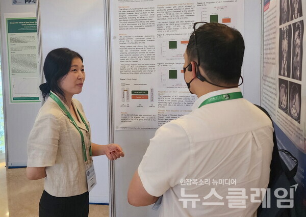 유정민 대웅제약 임상연구팀원(왼쪽)이 해외 의료진에 우루사 임상4상 관련 포스터를 소개하고 있다. 대웅제약 제공
