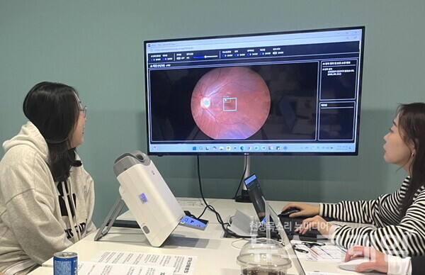대웅제약 임직원(왼쪽)이 AI 실명질환 진단 보조 솔루션 위스키(WISKY)와 안저카메라 옵티나(OPTiNA Genesis)를 이용해 3대 실명질환 검사를 받은 후, AI 판독 결과를 확인하고 있다. 대웅제약 제공