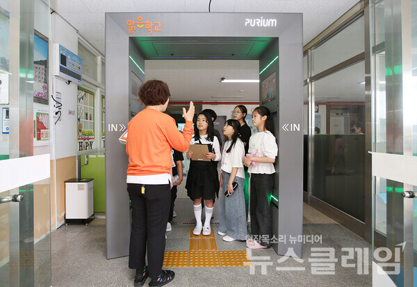 정읍 남초등학교 선생님과 학생들이 맑은학교 만들기를 통해 조성된 에어샤워를 사용설명을 듣고 있다. 한화그룹 제공