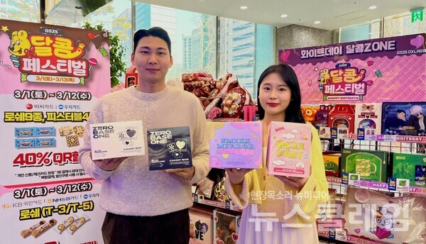 GS25 화이트데이 행사 존에서 모델이 제로베이스원 굿즈 세트, NMIXX 굿즈 세트를 들고 포즈를 취하고 있다. GS25 제공