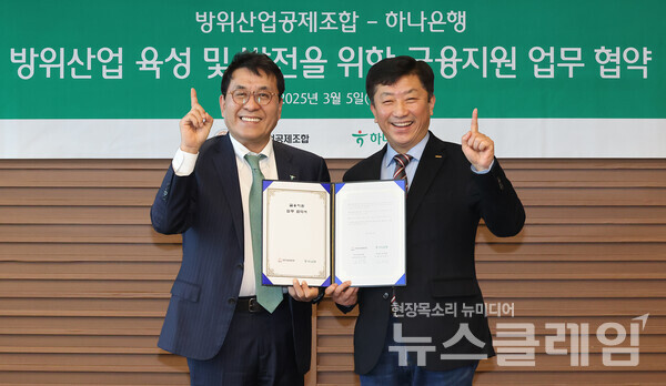 협약식에 참석한 김진우 하나은행 중앙영업그룹 부행장(사진 왼쪽)이 김희철 방위산업공제조합 상근부이사장(사진 오른쪽)과 협약서를 들고 기념촬영을 하고 있다. 하나은행 제공