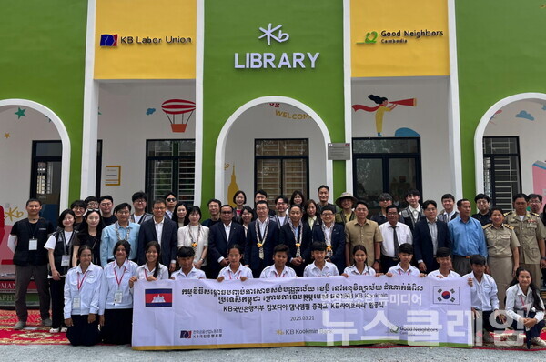 지난 21일 캄보디아 프놈펜에 위치한 댐낙앰필 중학교에서 열린 ‘KB라이브러리’ 완공식에 정훈영 KB국민은행지부 수석부위원장(두번째 줄 왼쪽에서 7번째), 옴쌈이온 KB 프라삭 은행장(두번째 줄 왼쪽에서 6번째), 장동원 굿네이버스 캄보디아 대표(두번째 줄 왼쪽에서 9번째)가 기념촬영을 하고 있다. KB국민은행 제공