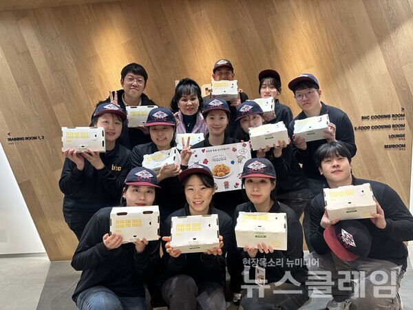 다이닝브랜즈그룹 공채 신입사원이 사회복지시설 관계자에게 치킨을 기부하고 기념사진을 찍고 있다. 다이닝브랜즈그룹 제공