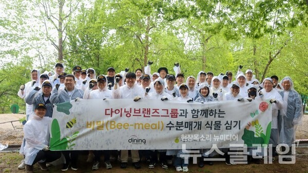 다이닝브랜즈그룹 임직원들이 수분 매개 식물 심기 캠페인 단체사진을 촬영하고 있다. 다이닝브랜즈그룹 제공