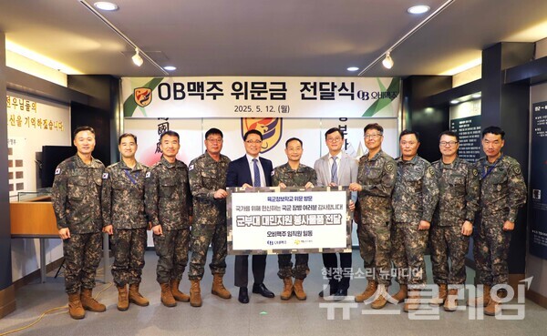 12일 오비맥주 최상범 영업부문 부사장(왼쪽에서 다섯 번째), 육군정보학교장 박민영 준장(여섯 번째), 오비맥주 강석빈 성남지점장(일곱 번째)이 위문품 전달식 후 기념식 사진을 찍고 있다. 오비맥주 제공