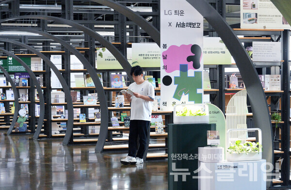 LG 틔운 미니를 활용해 조성된 내부 서가와 열람실 공간에서 독서하며 다양한 식물을 감상하는 모습. LG전자 제공