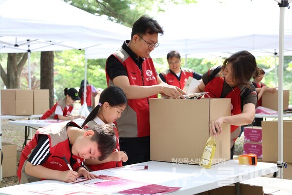 롯데건설 ‘샤롯데 봉사단’이 국가유공자 보훈가정을 위한 응원카드를 작성하고 기부물품을 포장하고 있다. 롯데건설 제공