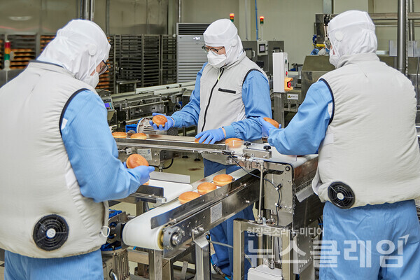 SPC그룹(회장 허영인) 던킨 안양공장 직원들이 온열 질환 예방을 위해 마련된 냉풍조끼를 입고 작업하고 있다. SPC그룹 제공