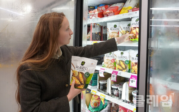호주 울워스 매장에서 한 고객이 진열된 비비고 만두를 고르고 있다. 사진=CJ제일제당(회장 이재현)