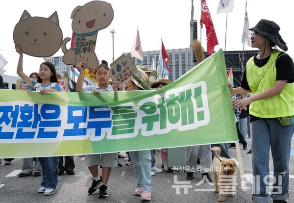27일 서울 종로구 광화문 동십자각 앞에서 열린 ‘기후정의 행진’ 참가자들이 피켓과 홍보물을 들고 기후위기 대응과 불평등 해소를 촉구하며 도심 행진을 벌이고 있다. 사진=최인기 빈민운동가