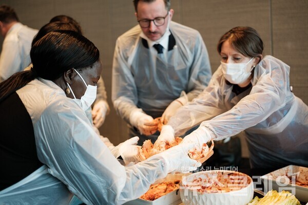 지난 21일 열린 롯데호텔앤리조트의 ‘김치의 날 외교 오찬 행사’에서 각국 대사들이 김장 체험을 하고 있다. 롯데호텔앤리조트 제공